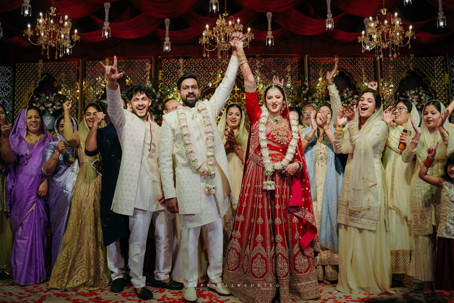 A richly designed wedding celebration beneath red drapery